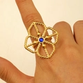 Detail of a large gold hollow flower ring featuring a faceted blue center gemstone - Sapphire Hollow Flower (4374)