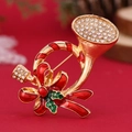 Detail of Christmas trumpet brooch with gold metal, green enamel and red bow rhinestones - Christmas Trumpet (WBR287)