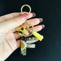 Detail of resin letter F keychain with white daisy, gold bee charm and yellow tassel - Letter F