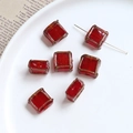 Macro shot of vintage red square beads with gold trim for DIY jewelry making - Burgundy