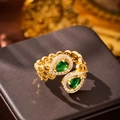 Macro shot of gold ring featuring green pear-shaped gemstones and white zircon pave setting - Ring / 10425-Green Pear Ring