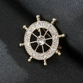 Golden ship wheel lapel pin for men with sparkling white crystals on black leather - Rudder Gold
