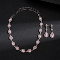 Vista detallada del collar de cristal rosa en forma de gota y pendientes a juego - Rosa