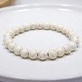 Detailed macro shot of white howlite beaded bracelet with natural marble texture on tray - 13# (White Crackle Howlite)
