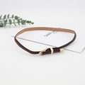 Macro shot of dark brown braided belt featuring polished gold buckle and metal tip accents - Brown Braided Texture Gold Buckle Style (17)