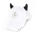 Detail of white baseball cap featuring black demon horns and punk metal ring accents - Skull White