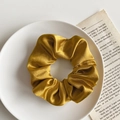 Lustrous gold satin scrunchie featuring elegant pleats on a minimalist white display tray - 1076i Golden Satin Scrunchie
