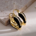 Macro shot of French vintage gold hoops with black enamel and white zircon details - Black