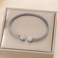 Dettaglio ravvicinato di un bracciale rigido a rete argento con estremità cilindriche incise - Stile Trama a Maglia Aperta / Color Acciaio (KB187715-XY)