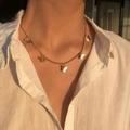 Golden butterfly necklace pendant detail shown on a model under sunset lighting - Necklace / Gold