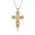 Dettaglio macro della collana a croce dorata con cuore e inserto in pietra verde - Verde