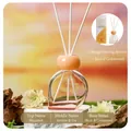 Elegant orange reed diffuser with cedar and jasmine scent against a warm sunset background - Cedar Kiss 80ml