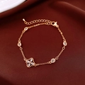 Detalle de pulsera de flor en oro rosa con circonitas ovales sobre fondo de seda oscura - Estilo Trébol Chapado en Oro Real / Dorado