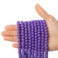 Runde lila Polymer-Ton-Perlen für DIY-Schmuckherstellung in einer Hand präsentiert - Lila
