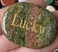 Polished oval Unakite natural crystal stone featuring golden Lucky engraving - Unakite