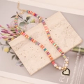 Colorful clay bead necklace with faux pearls and black heart pendant on beige stone base - Mixed Colorful