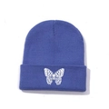 Close-up of white butterfly embroidery on blue ribbed knit beanie hat for winter - One Size / Dark Blue