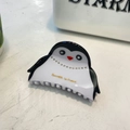 Macro detail of penguin acetate hair claw with rhinestones and Barrette la France text - Penguin