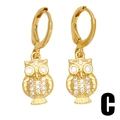 Détail de boucles d'oreilles hibou dorées avec décoration en micro-pavage de zircons brillants - Style Chouette / Or