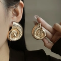 Detailed view of oversized golden spiral shell earrings with embossed metal texture - E4985 Spiral Shell Style / Gold