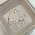 Elegante pulsera de perlas con cadena dorada y cierre en una caja de regalo beige - Pulsera (WB1979)
