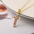 Dettaglio di un ciondolo a croce placcato oro 18K con zirconi rosa e bianchi - Rosa