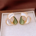 Detailed macro view of two-tone flower petal earrings on a premium linen jewelry box cushion - Gold-White-Green (Abstract Petal)