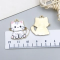 Grey striped cat pendant charm in gold alloy with pink paw details and scale reference - 1 Piece / White