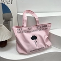 Pink canvas tote bag with black floral silhouette print and artistic typography - Pink