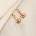 Macro shot of gold hoop earrings featuring intricate filigree and oval red gemstone inlays - Red Gemstone Earrings