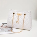 White quilted shoulder bag with gold chain strap and deer charm on a white surface - White
