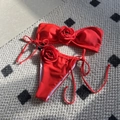 Red bikini set with 3D rose appliques and side-tie bandeau top on textured rug - Red