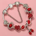 Detail of silver snake chain bracelet with red lips, crown, and cherry charms - Sl023318/1216-11