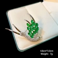 Detailed size view of silver swallow brooch with green gemstones on white velvet - B1148/Green Swallow Shape