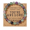 8mm purple and green natural stone bead bracelet presented on a kraft paper gift card - Fluorite