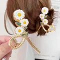 Elegant gold-plated metal shark clip featuring white daisy flowers and green leaves - Daisy Shark Clip