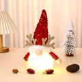 Dettaglio dello gnomo natalizio luminoso con corna di renna e paillettes rosse - Rosso