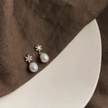 Macro detail of baroque pearl earrings with zircon floral studs on a ceramic tray - Style 13