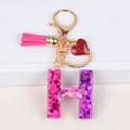Letter H resin keychain with pink glitter, suede tassel and glittery heart pendant - Letter H