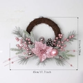 Front view of pink poinsettia Christmas wreath with pine cones and silver ornaments - 45cm Half Wreath
