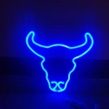 Detailaufnahme des blau leuchtenden Bullenkopf-Neon-Schilds in dunkler Umgebung - Blau
