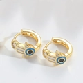 Makroaufnahme goldener Hand-Ohrringe mit blauem Devil's Eye Emaille und Zirkonia - Weiß