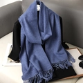 Dettaglio sciarpa blu in finto cashmere con nappe su vassoio di legno per inverno - Blu