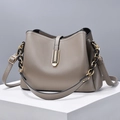 Taupe pebbled leather handbag with gold-black chain and adjustable strap on geometric platform - Gray