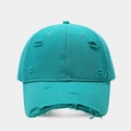 Close-up detail of vintage distressed holes and frayed edges on the cyan cotton baseball cap - Teal