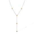 Macro detail of golden Y-shaped necklace featuring five small heart charms on a fine chain - Heart Style