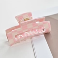 Close-up of pink and cream checkerboard acetate hair claw clip with metal spring detail - Pink/White Plaid Rectangle