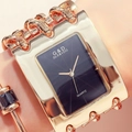 Close-up of golden square quartz watch and matching bracelet on a female wrist - Black Dial Gold Strap Without Diamonds