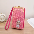 Chic pink sequin crossbody handbag with cute knitted bunny charm on wooden table - Red