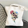 Detail of canvas tote bag with skull and floral print on a chair in a bright setting - Colorful Skull Rose